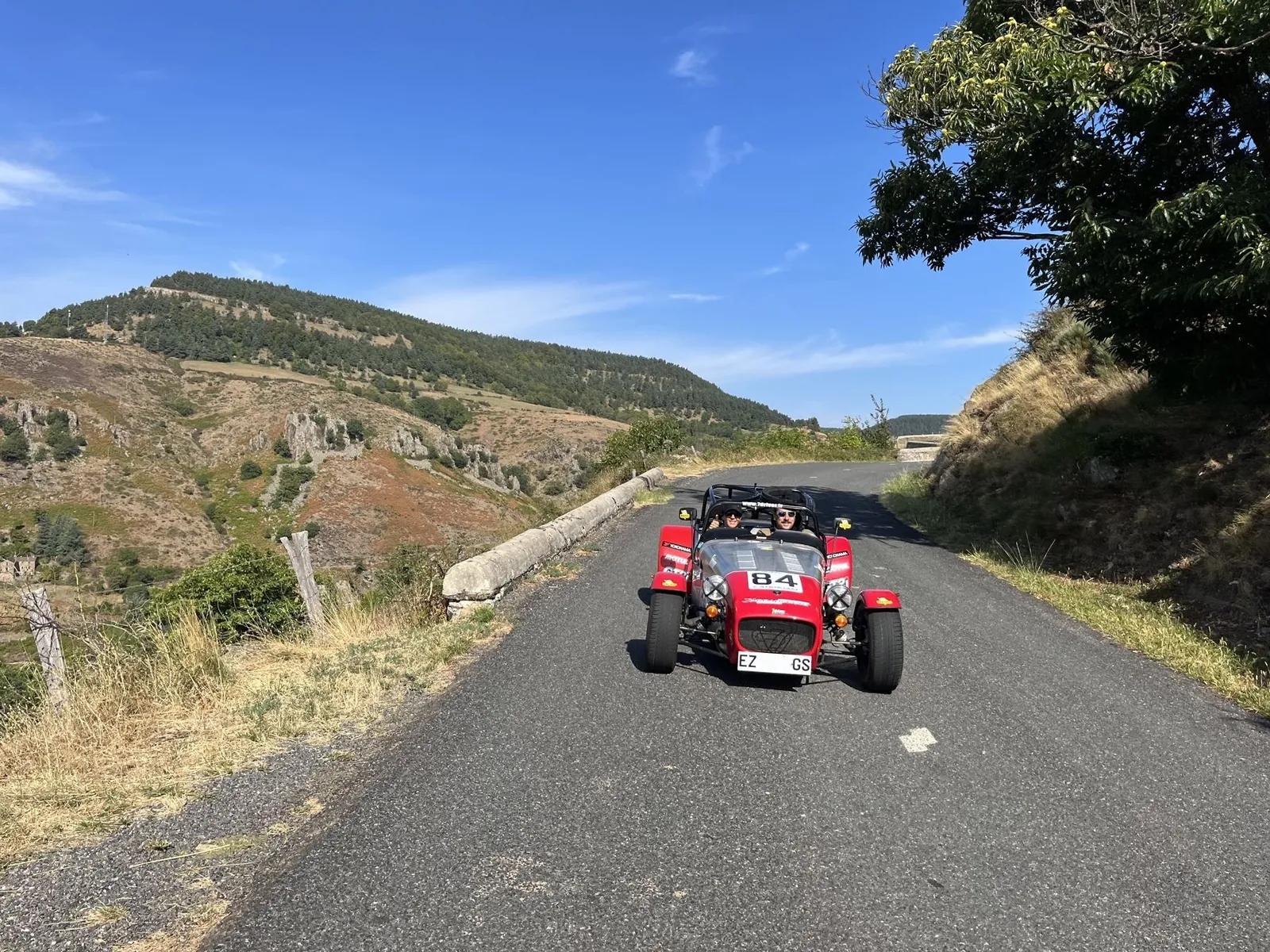 Caterham sur une route des Cévennes, montagne en fond