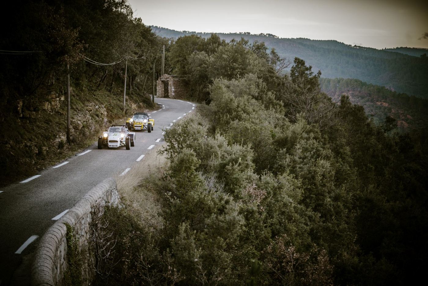 Deux Caterham sur une route de montagne